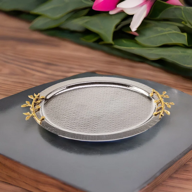 A gold and silver Leaf Oval Tray with flowers next to it.