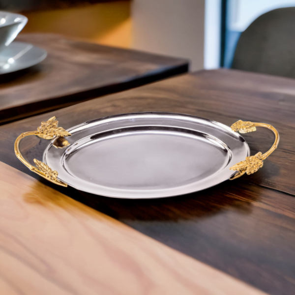 An Ayla Tray with gold handles on a wooden table.