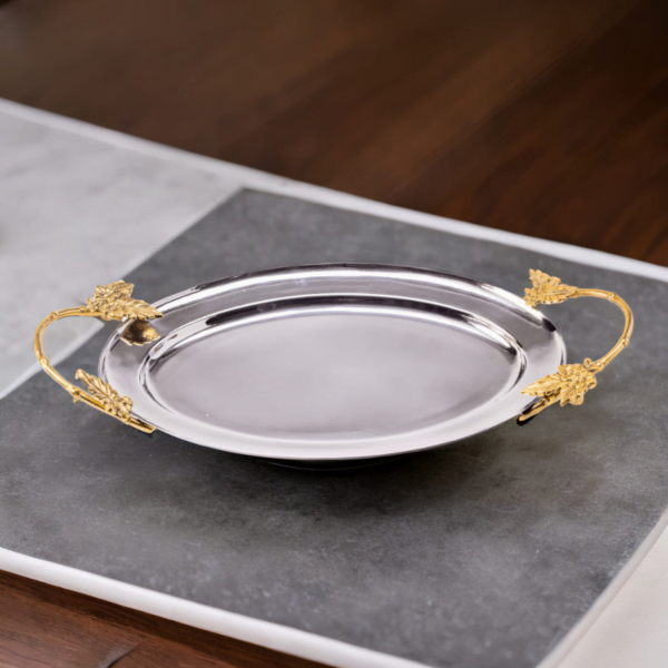 An Ayla Tray with a gold handle on a table.