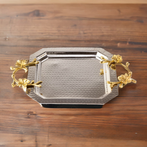 An Octagon Silver Tray with gold handles on a wooden table.