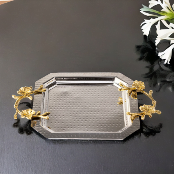 An Octagon Silver Tray with gold handles and flowers on it.