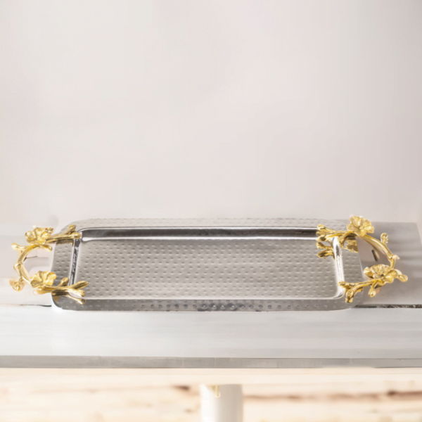 A Long Floral Tray with gold handles on top of a table.