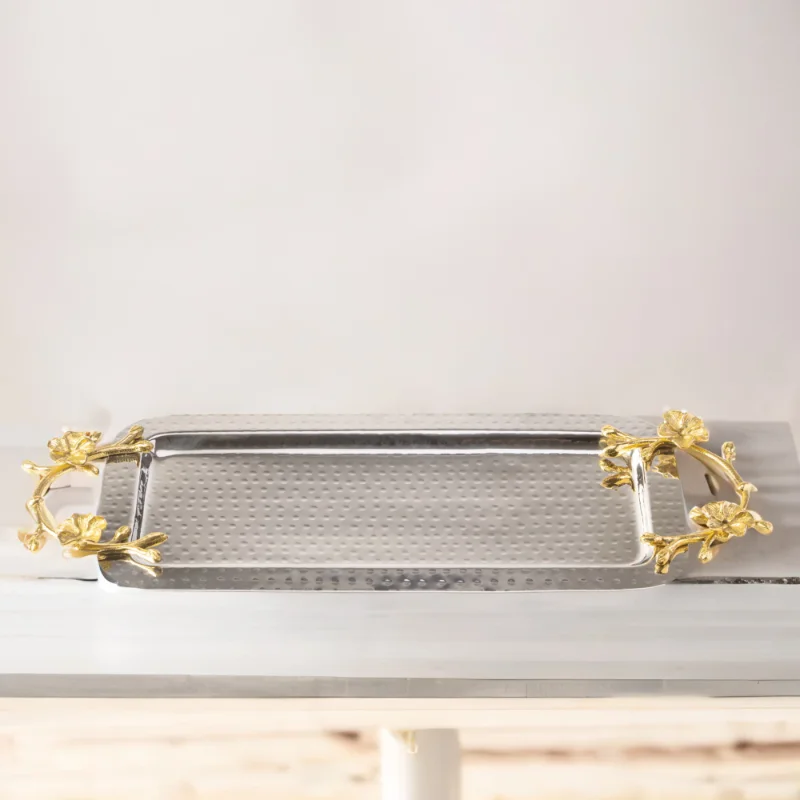 A Long Floral Tray with gold handles on top of a table.