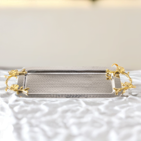 A Long Floral Tray with gold handles on a white table.