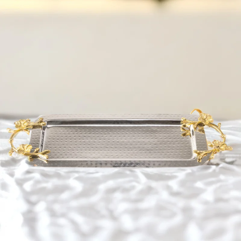A Long Floral Tray with gold handles on a white table.