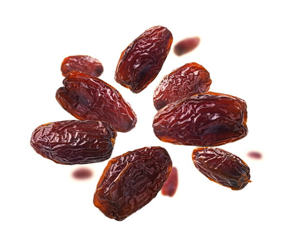 Dried dates levitate on a white background.