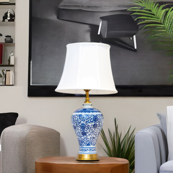 A blue and white lamp adorned with gold accents and stylish blue and white flower patterns on a side table in living room.