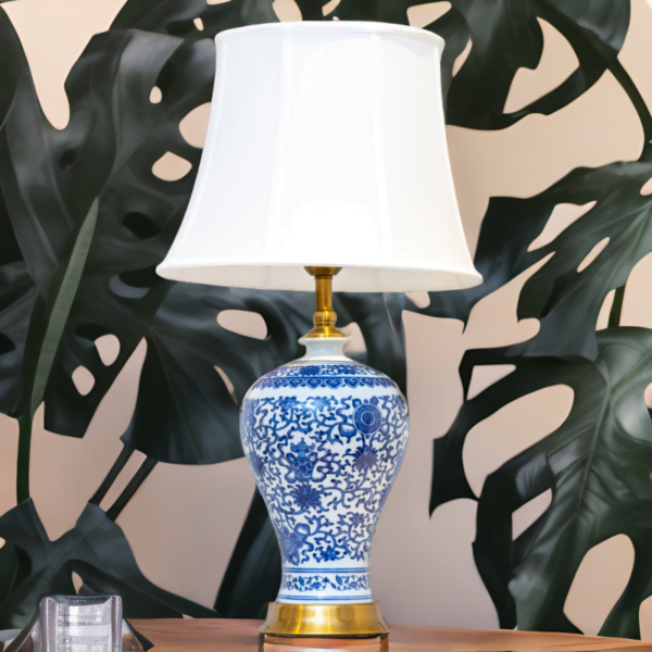 A blue and white lamp adorned with gold accents and stylish blue and white flower patterns.