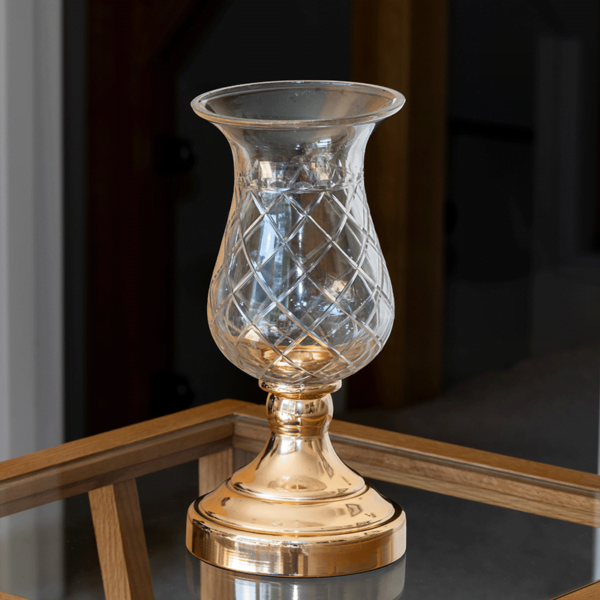 A beautiful candle holder in an elegant mix between Gold metal and Glass.