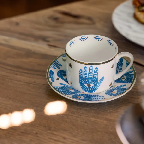 A blue and white Hamsa Blessings Set on a wooden table.