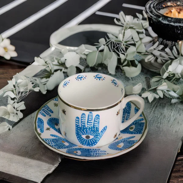 A Hamsa Blessings Set cup and saucer on a black tray.