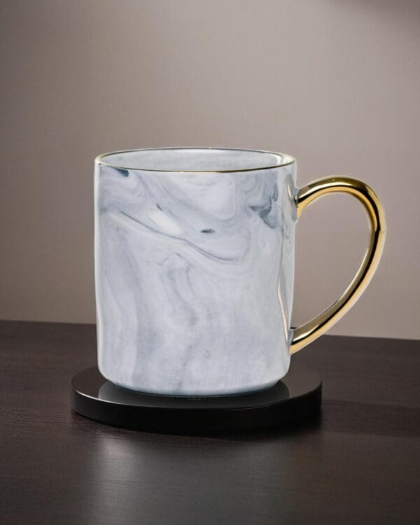 Ceramic mug with a granite look and a golden handle.