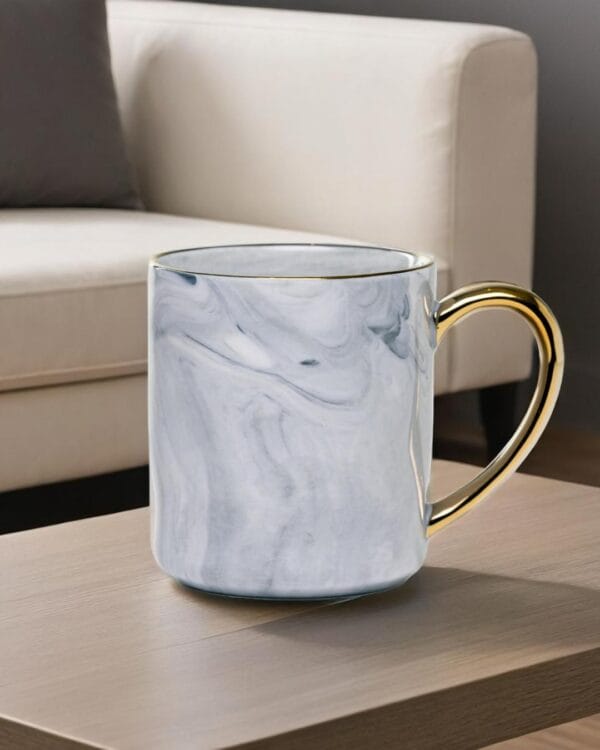 Ceramic mug with a granite look and a golden handle.