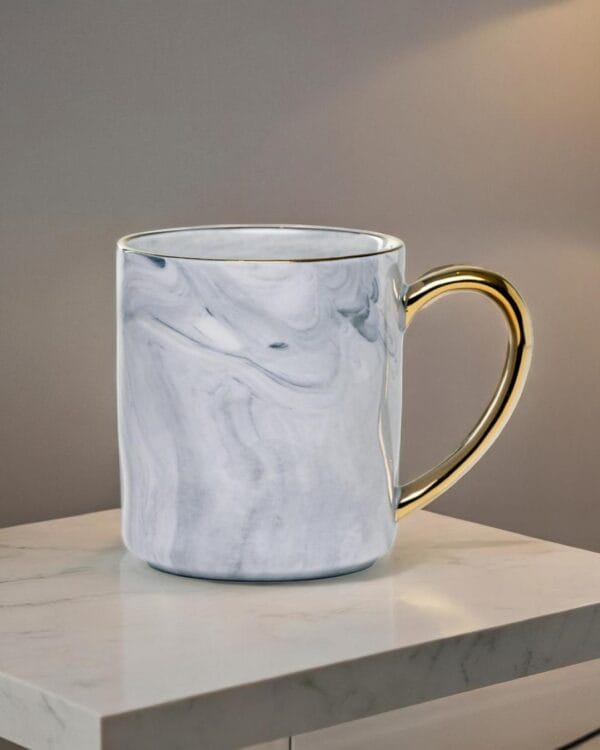 Ceramic mug with a granite look and a golden handle.