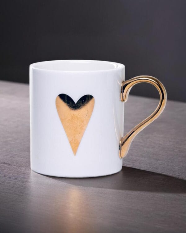 White ceramic mug adorned with a gold handle and a single golden heart