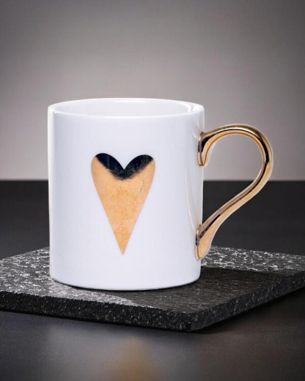 White ceramic mug adorned with a gold handle and a single golden heart