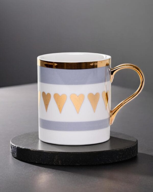 Ceramic mug adorned with golden hearts and a golden handle.