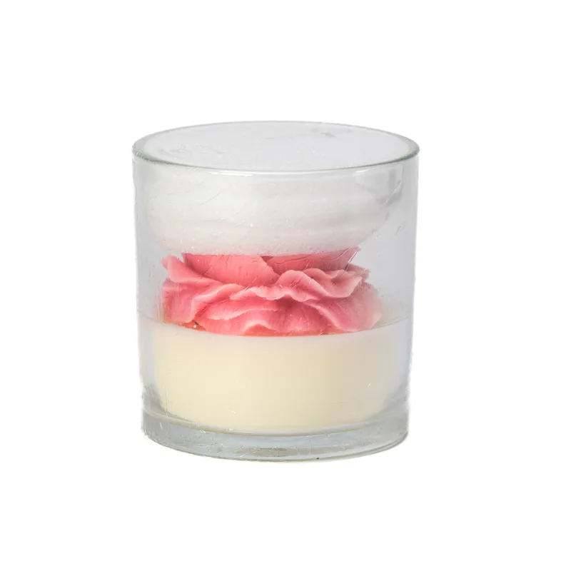 A rose candle in a glass jar features a pink and white flower-shaped wax design.
