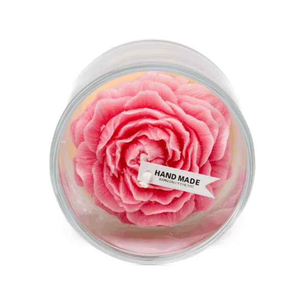 A rose candle in a glass jar features a pink and white flower-shaped wax design.