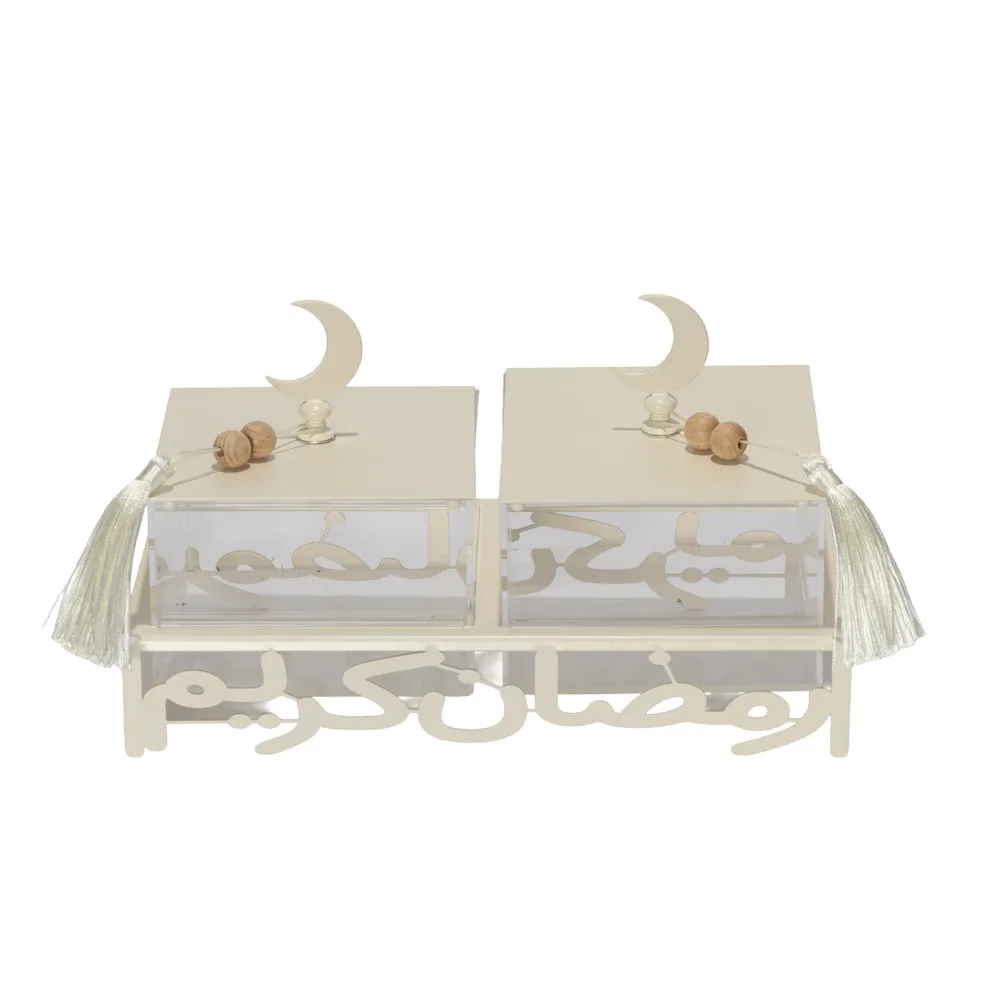 off white metal serving stand with Ramadan Kareem calligraphy cutout, holding two clear lidded acrylic boxes with tassel details.